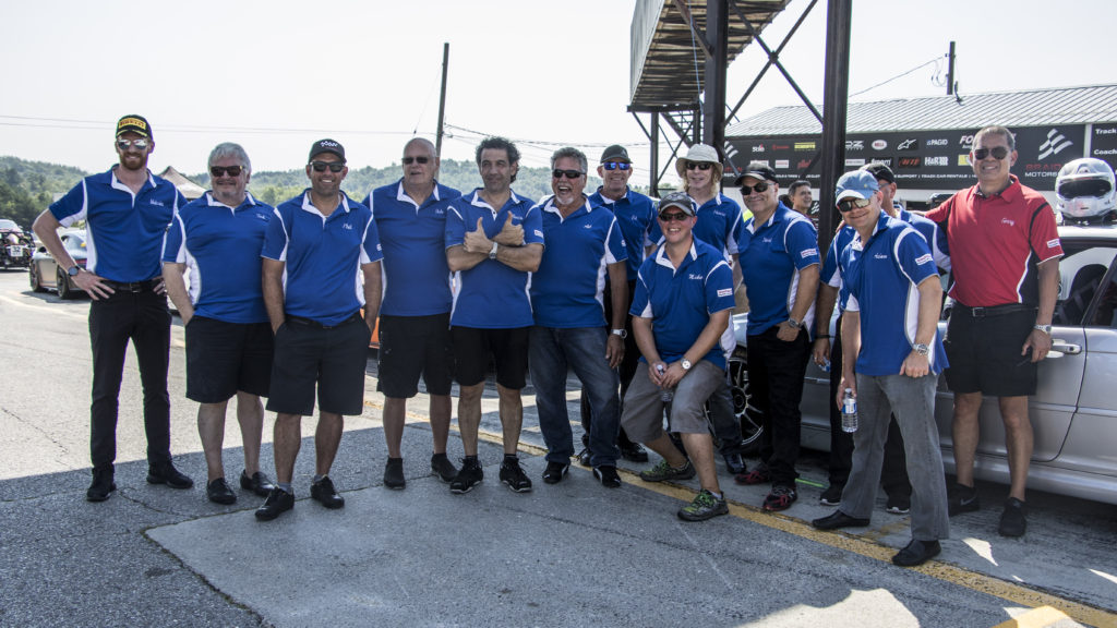 A team of pit crew workers in blue color shirts