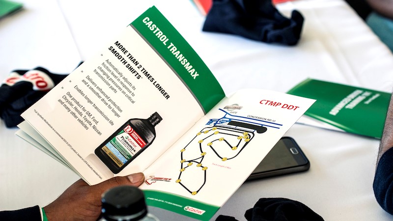 A person holding a Castrol booklet