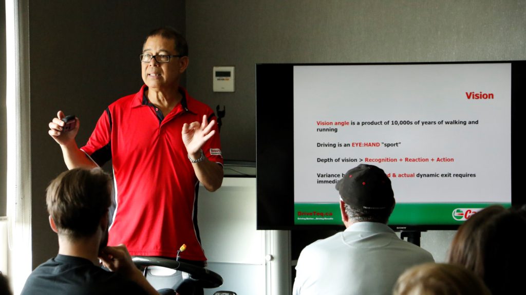 A man giving a presentation wearing a red shirt
