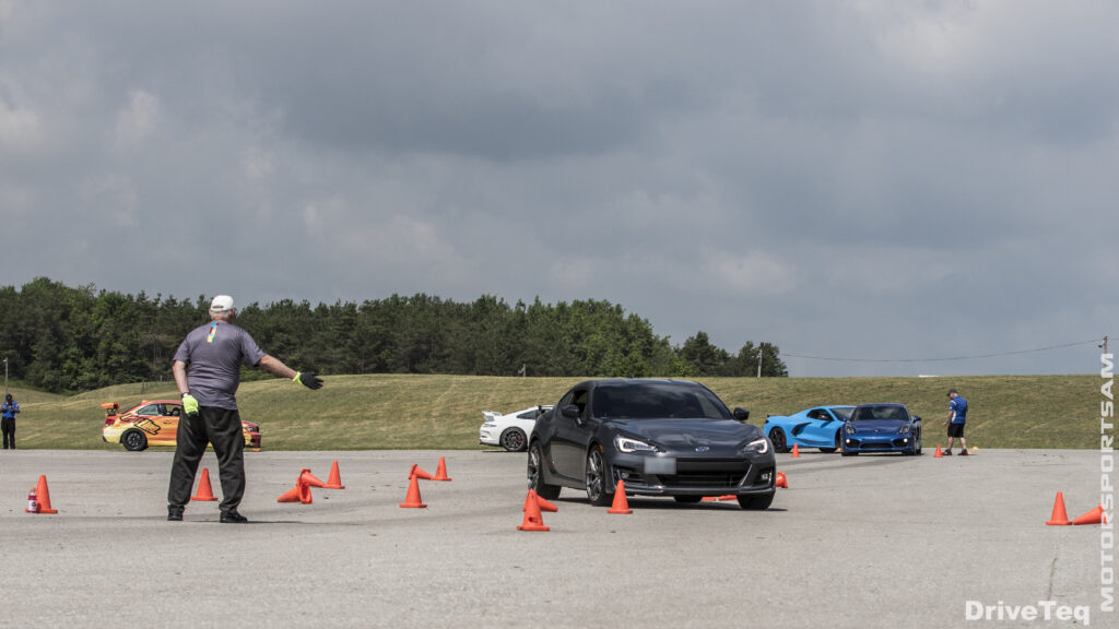 A person driving at a track with cones